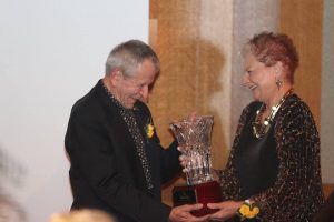 Bob Friese, AIFD, receives a plaque from Alice Waters, AIFD, welcoming him into the Michigan Floral Foundation's Hall of Fame 